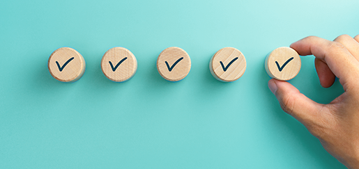 Check marks on wooden blocks on a teal background